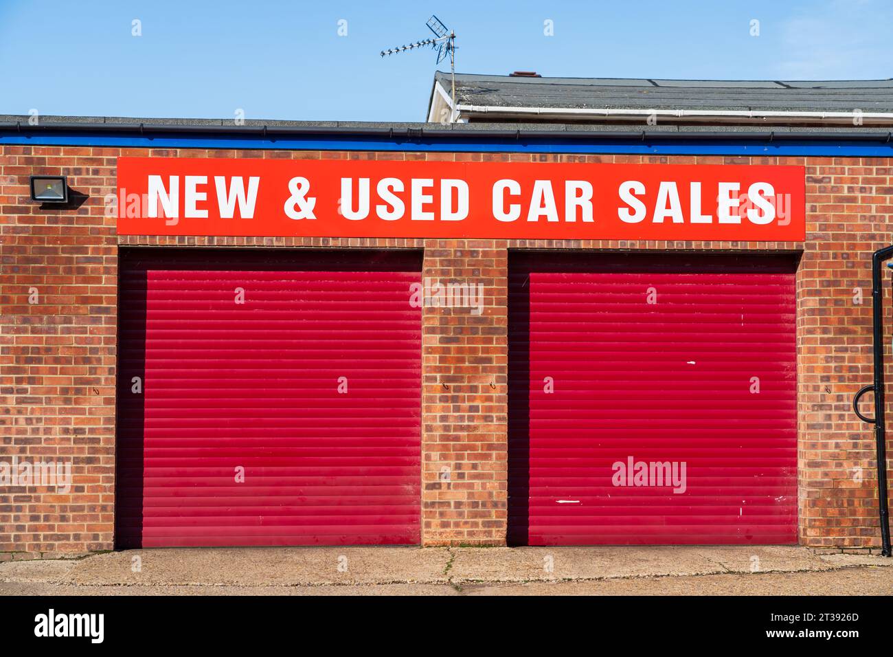 Porte di garage chiuse per un'attività di vendita di auto usate Foto Stock