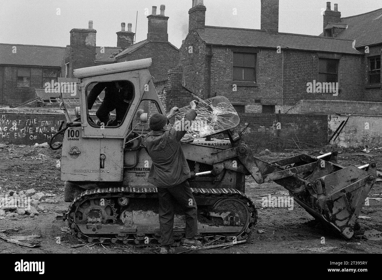 Gli appaltatori di demolizione cambiarono il parabrezza del loro bulldozer dopo che i manifestanti lo ruppero durante la slum di St Ann's, Nottingham. 1969-72 Foto Stock