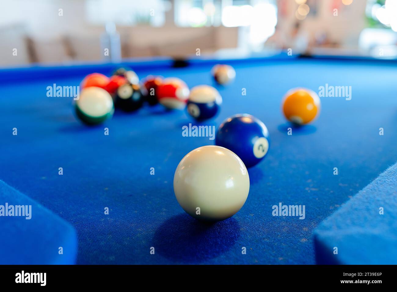 Primo piano di palline da biliardo colorate su un tavolo da biliardo blu alla luce del giorno Foto Stock