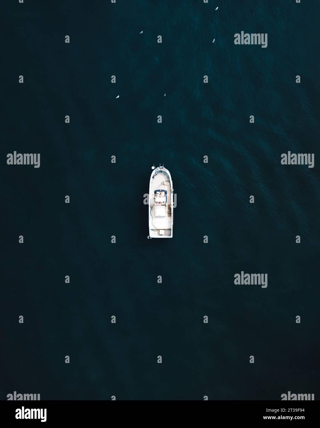 Vista aerea dall'alto di una piccola barca da pesca con attrezzatura ormeggiata in acque blu scuro a El Rompido Foto Stock