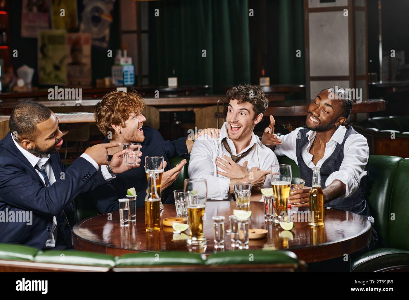 uomini multietnici felici che puntano ad amici al bar, amici maschi durante la festa di scapolo al bar Foto Stock