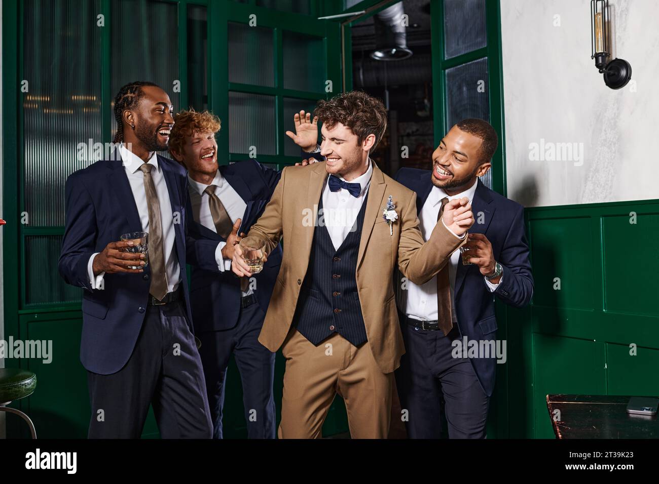 addio al nubilato, uomini migliori multietnici e sposo che ridono in piedi con un bicchiere di whisky Foto Stock