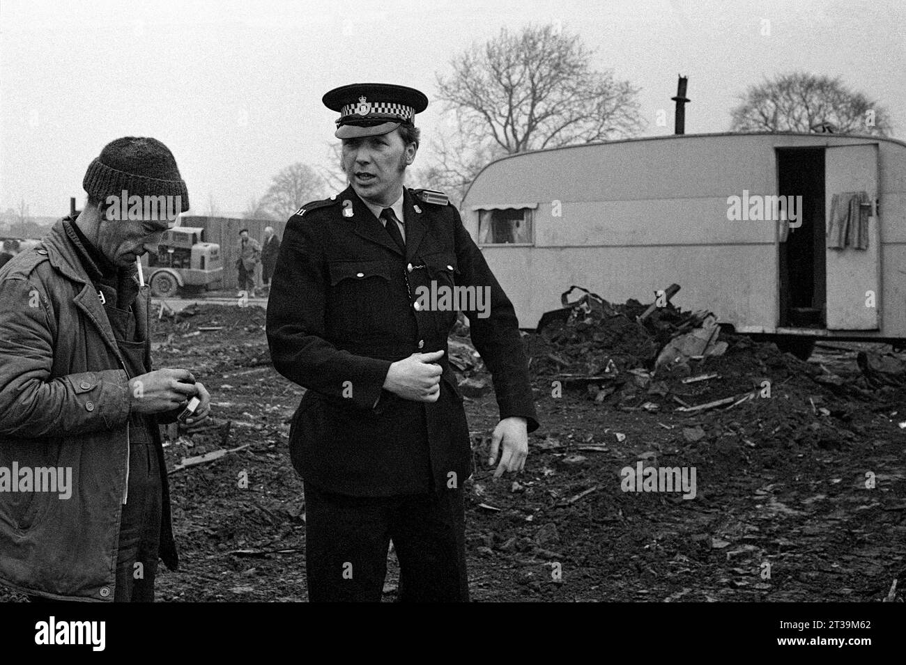 Poliziotto e un appaltatore di demolizioni nelle terre desolate accanto a una carovana viaggiatore durante lo sgombero e la demolizione di St Ann's, Nottingham. 1969-72 Foto Stock