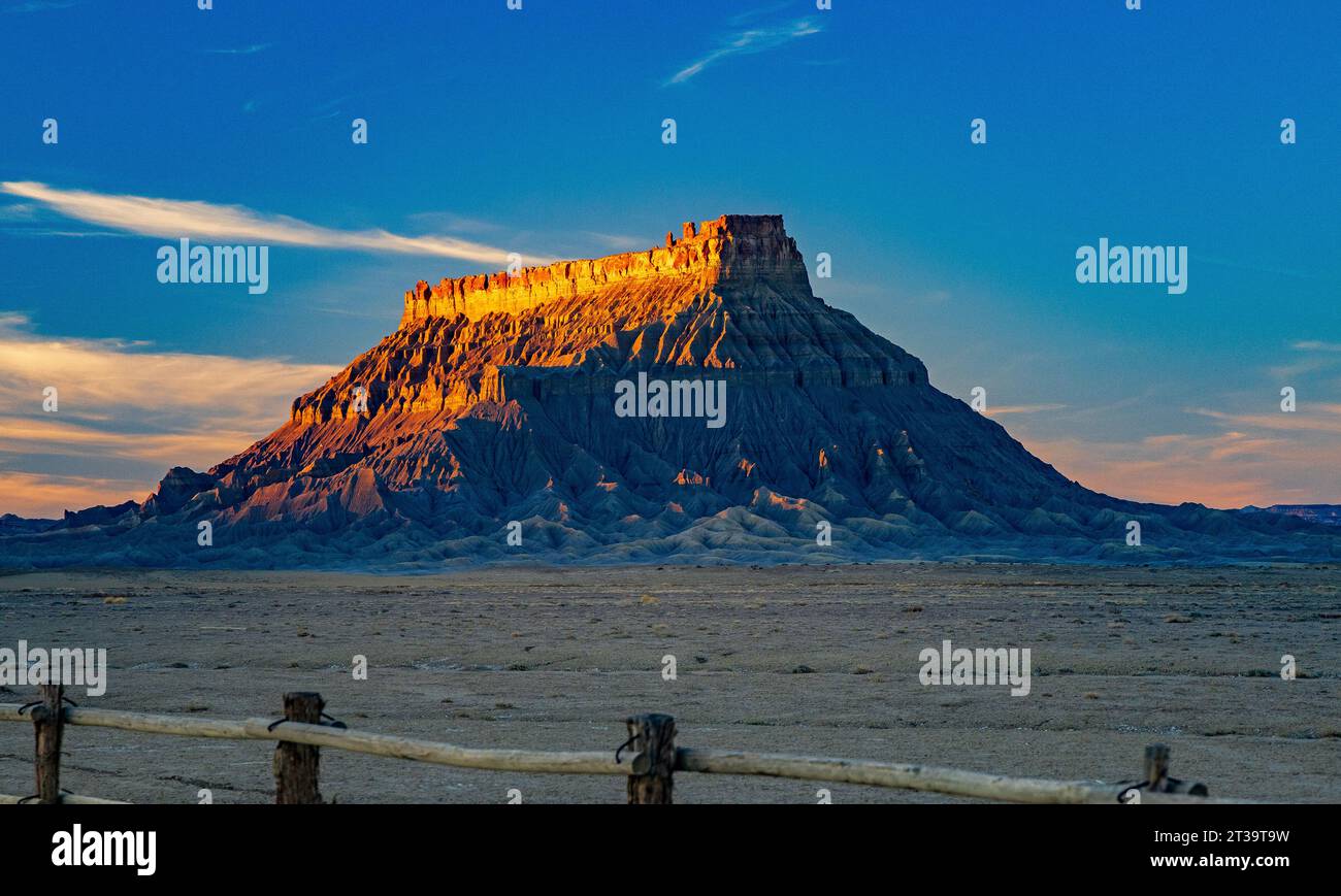 Il sole che tramonta illumina il lato ovest di Factory Butte, una montagna suggestiva vicino a Hanksville, Wayne County, Utah, Stati Uniti. Foto Stock