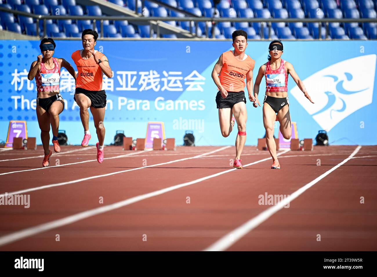 Hangzhou, provincia cinese di Zhejiang. 24 ottobre 2023. Liu Cuiqing (1st R) e la sua guida Chen Shengming (2nd R) della Cina, Zhou Guohua (1st L) e la sua guida Jia Dengpu gareggiano durante la finale femminile di atletica leggera 100m T11 ai 4th Asian Para Games a Hangzhou, nella provincia dello Zhejiang della Cina orientale, 24 ottobre 2023. Credito: Jiang Han/Xinhua/Alamy Live News Foto Stock