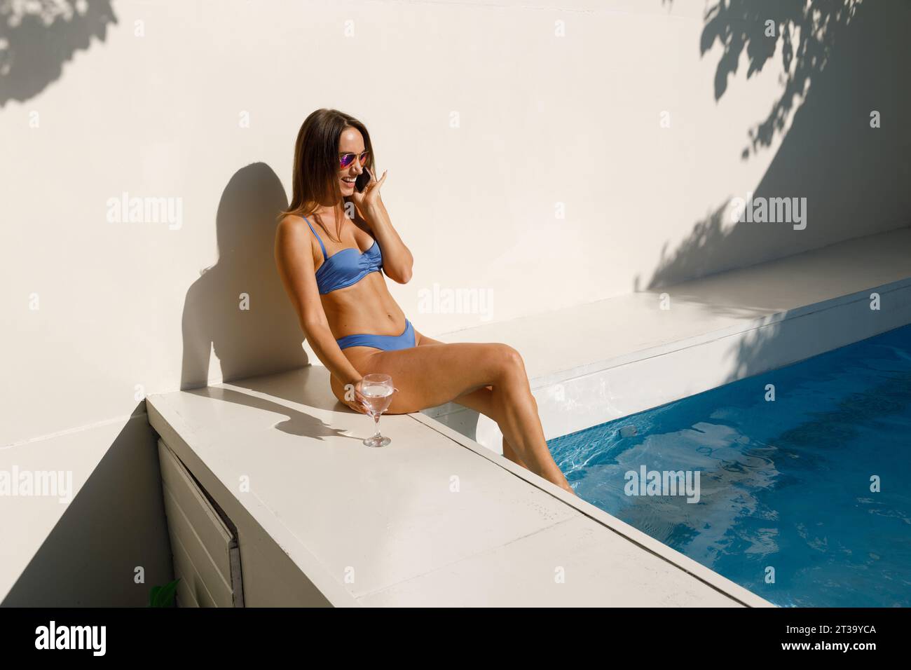 Bikini Babe Chatting by the Water Foto Stock