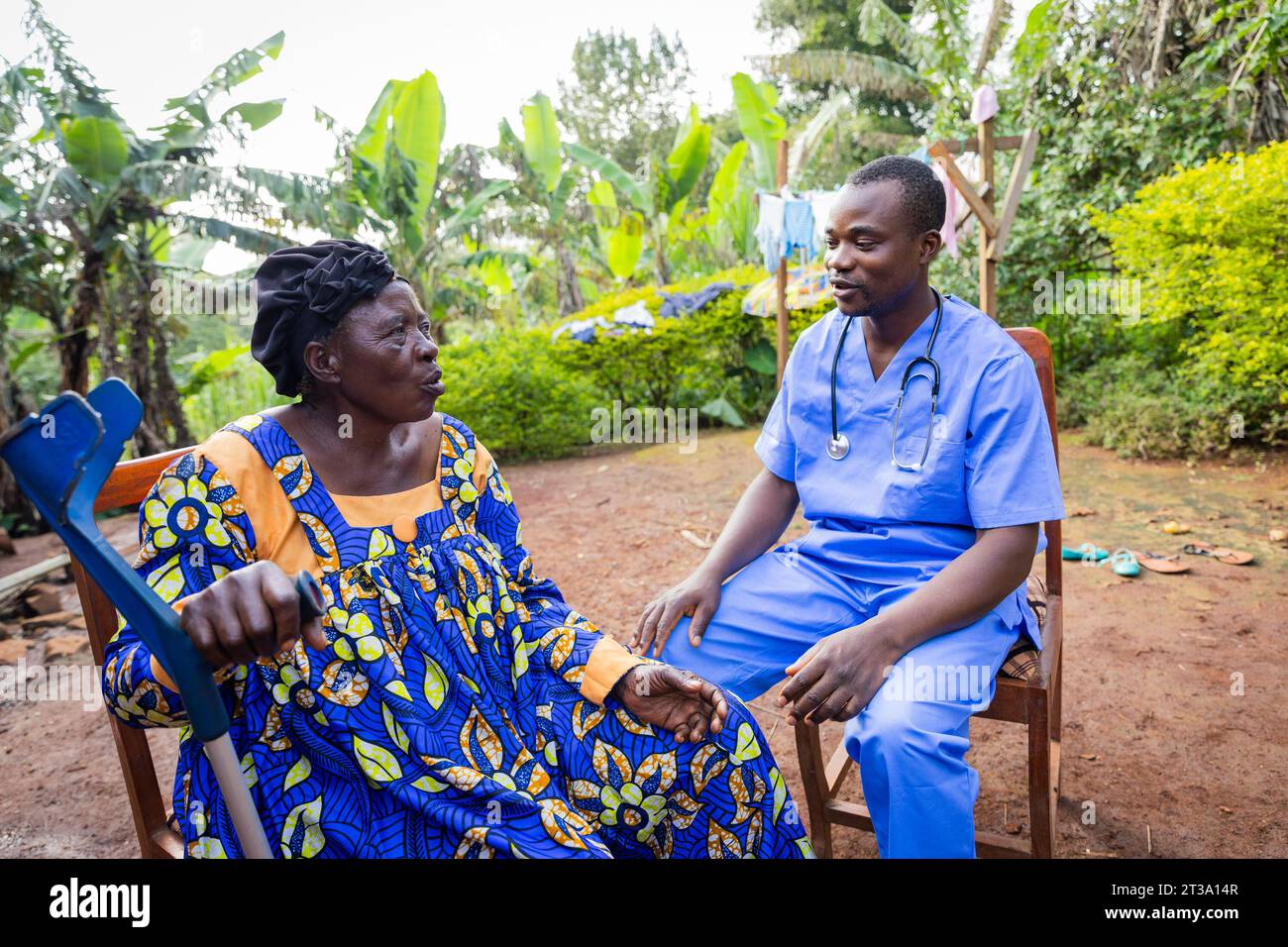 Un giovane medico africano fa visita a una vecchia donna malata. Visita a casa di un anziano malato. Foto Stock