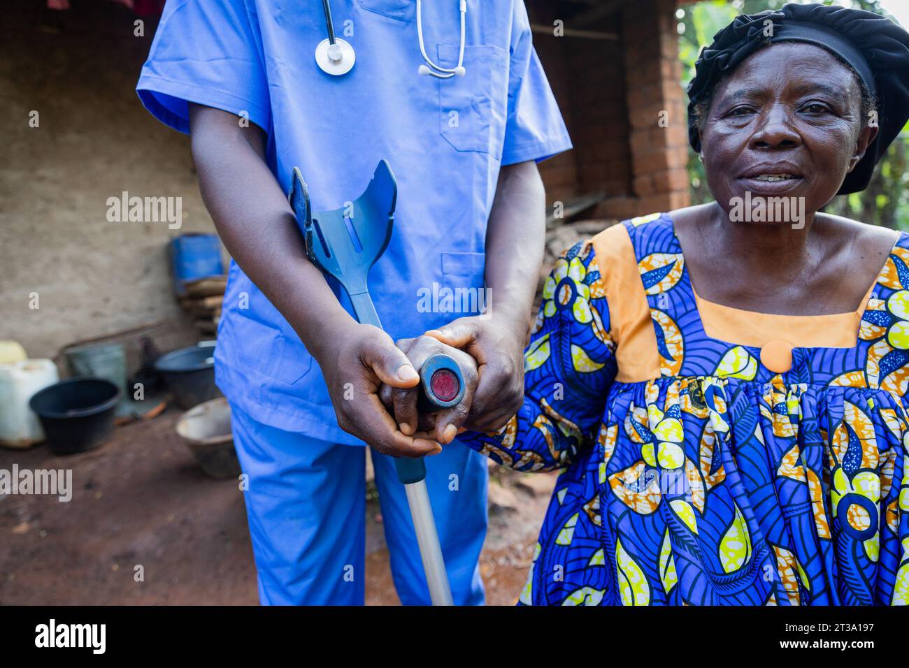 Medico professionista aiuta una vecchia signora con la mano su una stampella. Foto Stock