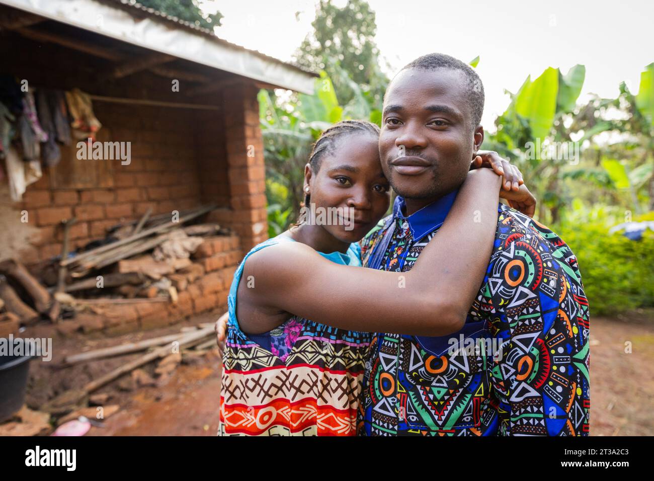 Giovane coppia africana innamorata si è abbracciata davanti alla loro casa nel villaggio. Foto Stock