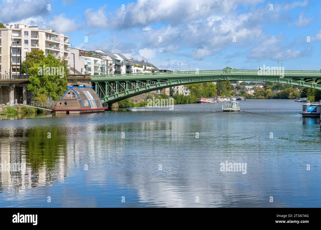 Insolita, barca chiamata Vaisseau Odyssee, ormeggiata sulle rive dell'Erdre. Il ponte si chiama Pont Général de la Motte Rouge. A Nantes, in Francia. Foto Stock