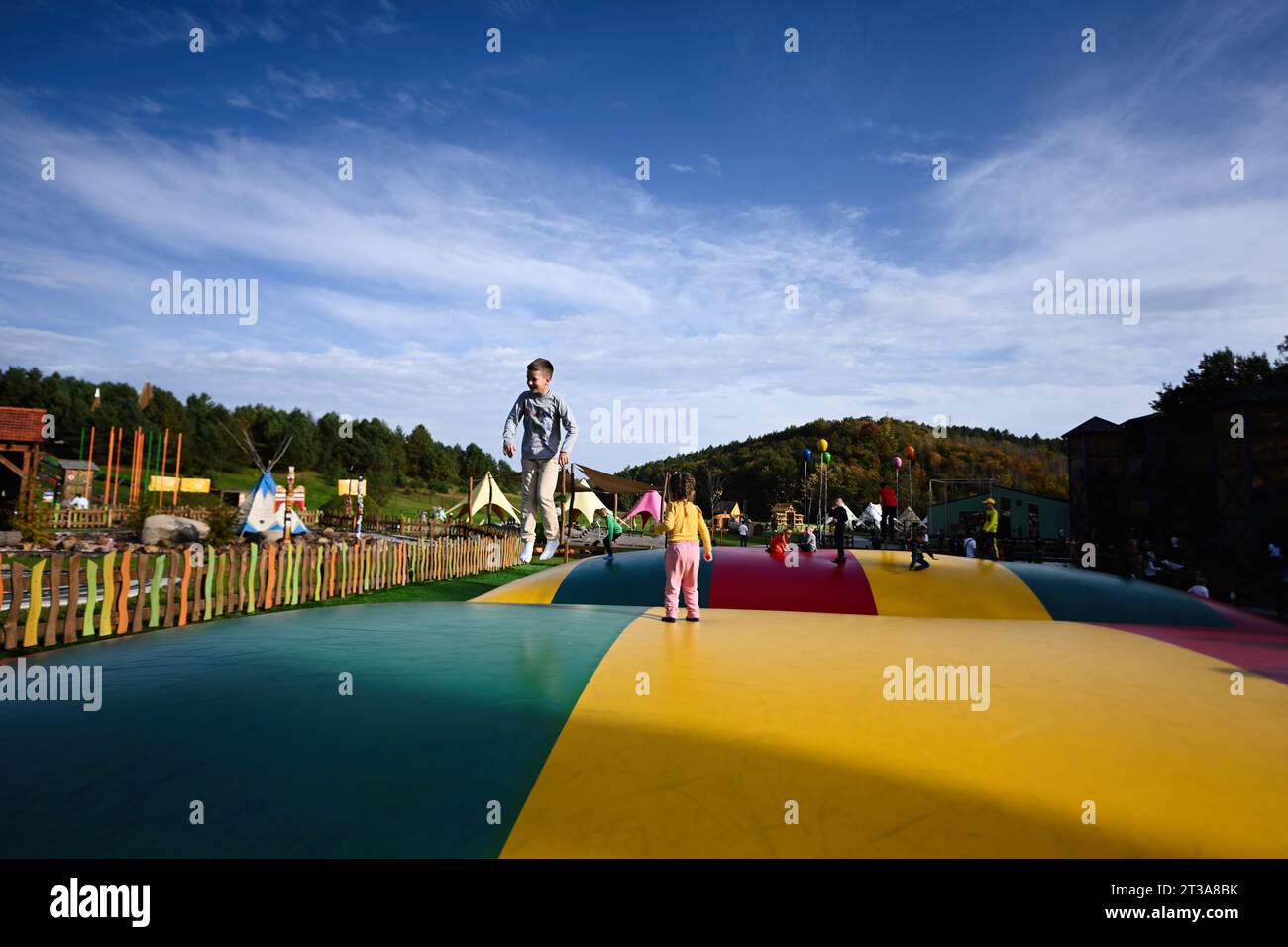 I bambini giocano su un trampolino nel parco divertimenti. Foto Stock