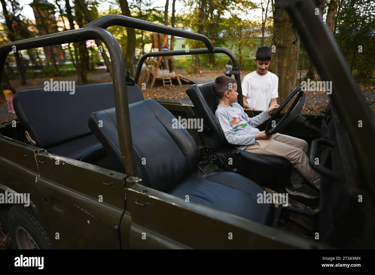 Due fratelli in auto decappottabile nella foresta autunnale. Foto Stock