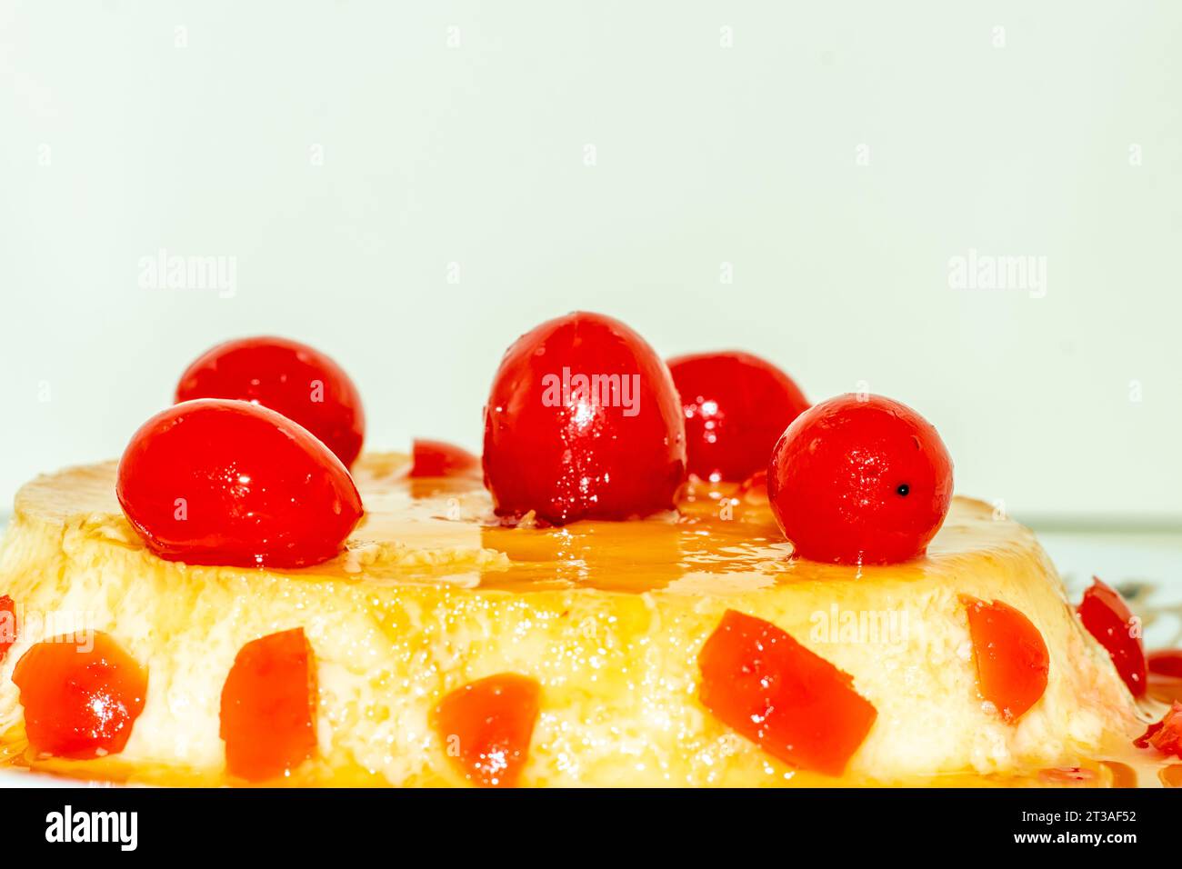 Un budino dal sapore meraviglioso preparato con latte d'uovo e zucchero e servito con frutti rossi di ciliegia Foto Stock