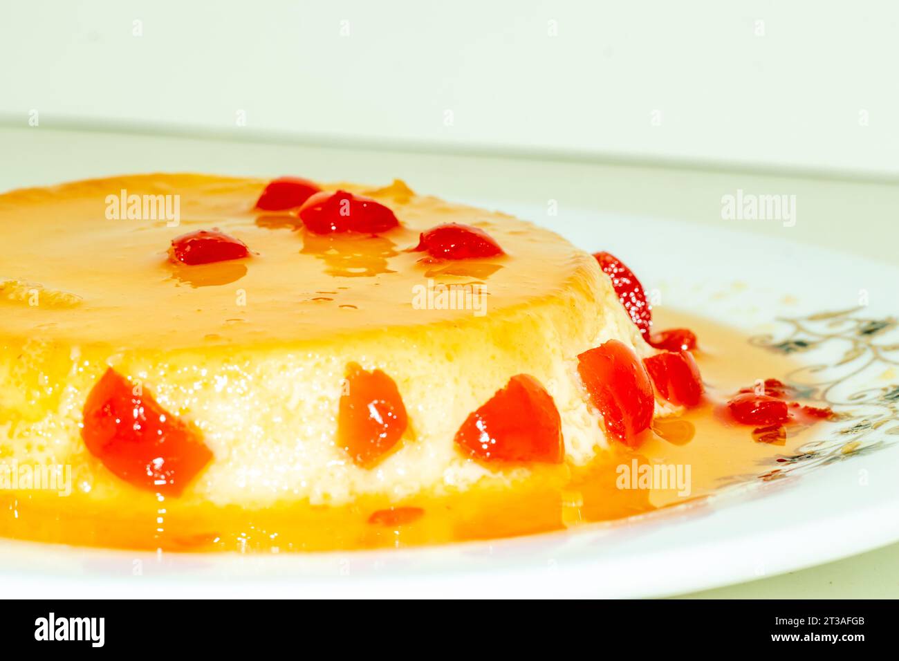 Per preparare il budino alla vaniglia da zero, il budino fatto in casa viene servito condito con frutta rossa alla ciliegia. Un budino è un dolce cotto preparato con ingredienti Foto Stock