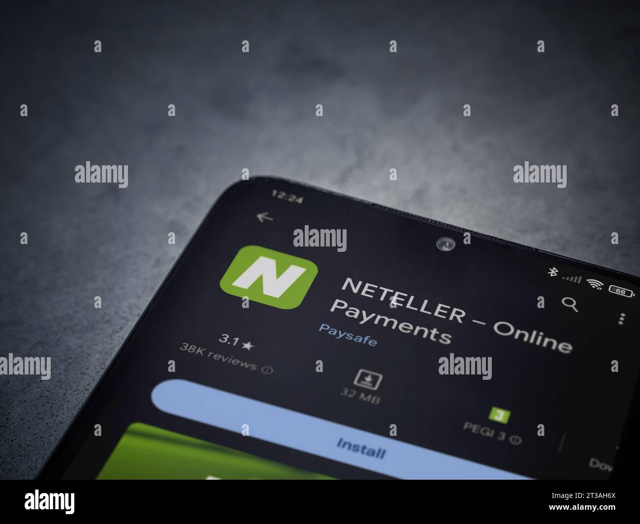 LOD, Israele - 16 luglio 2023: Pagina di gioco dell'app store NETELLER su smartphone su sfondo di marmo scuro. Vista dall'alto con spazio per la copia. Foto Stock