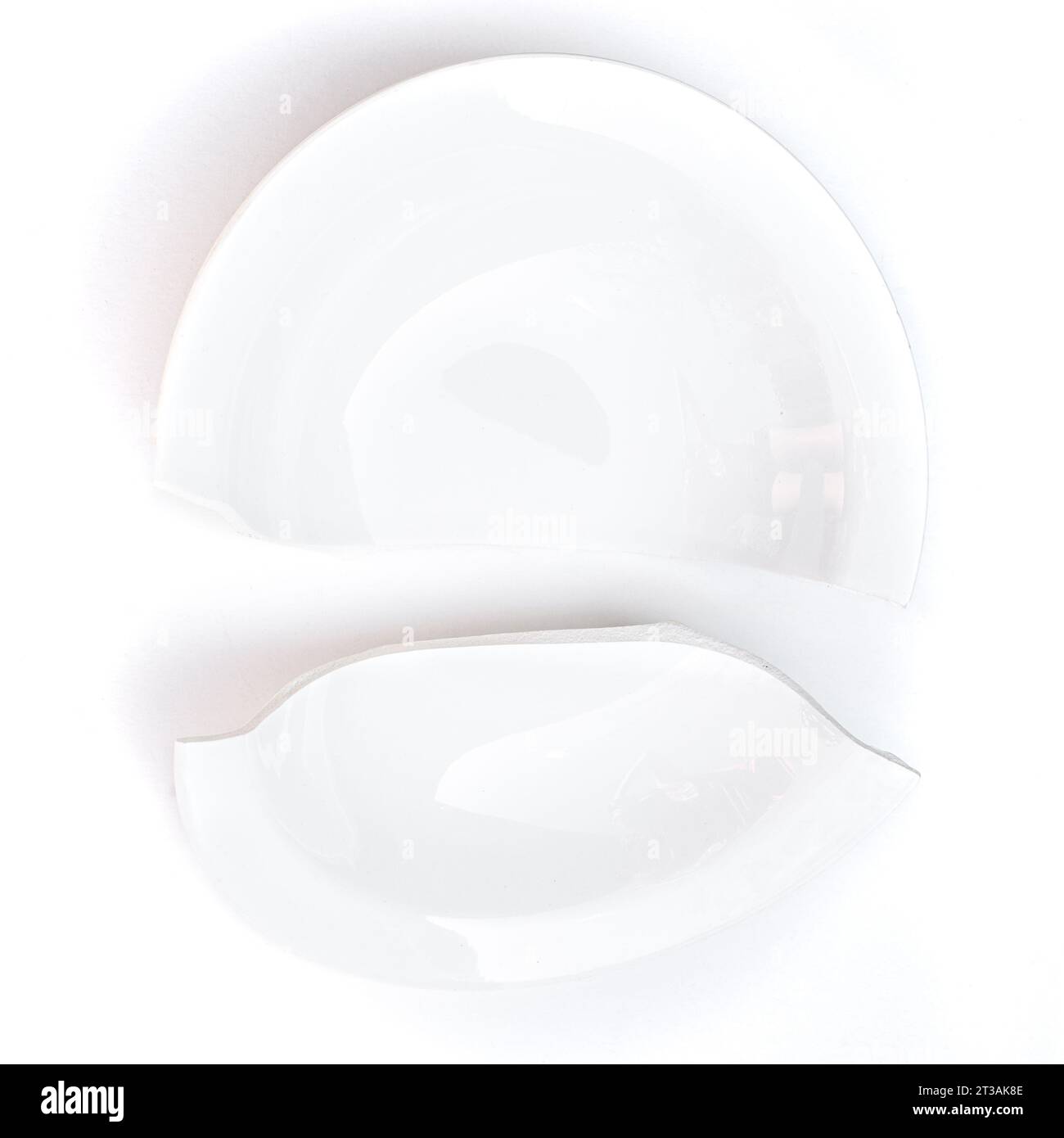 Due metà di una piastra bianca spezzata a metà su uno sfondo bianco. Foto Stock