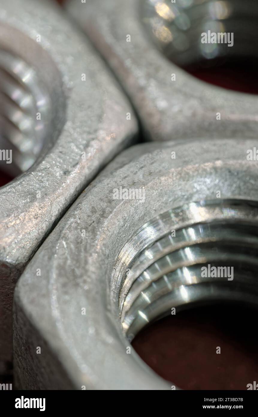 Gruppo di dadi in acciaio zincato, sfondo industriale astratto Foto Stock