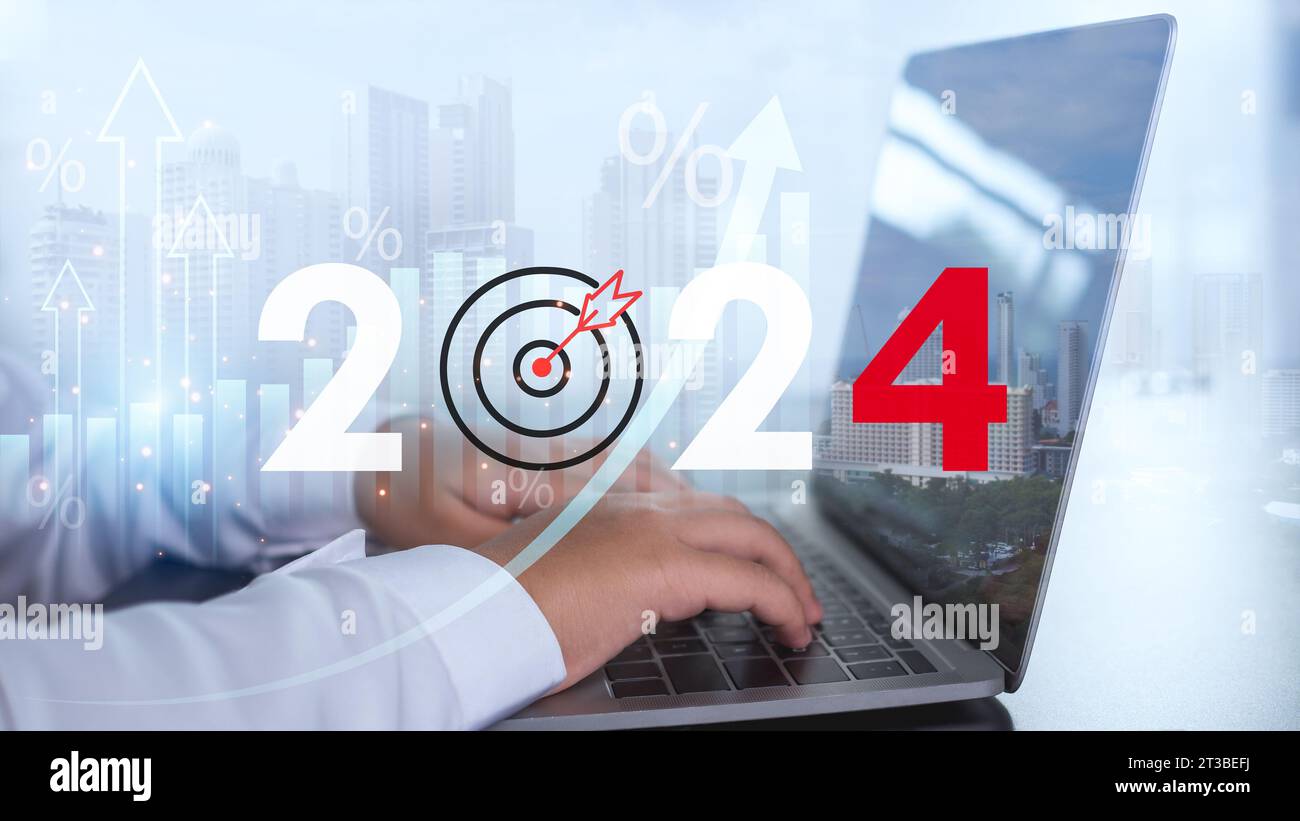 L'uomo d'affari sta usando un computer e mostra le lettere 2024 che rappresentano gli obiettivi per l'anno 2024 e il concetto di avviare un'attività insieme Foto Stock