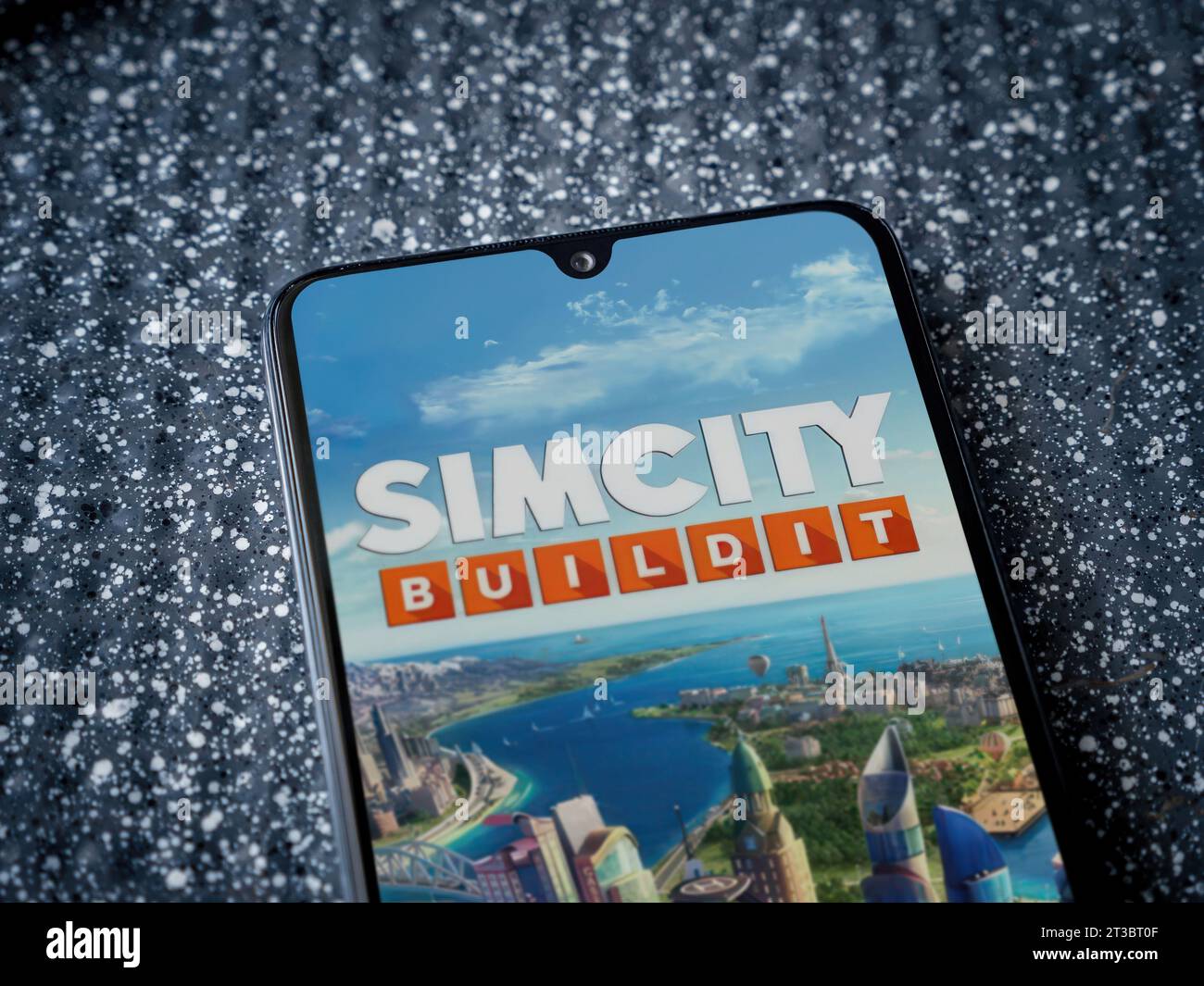 LOD, Israele - 16 luglio 2023: Schermata di avvio dell'app SimCity BuildIt sullo smartphone su sfondo metallico. Vista dall'alto ravvicinata, posizionamento piatto. Foto Stock