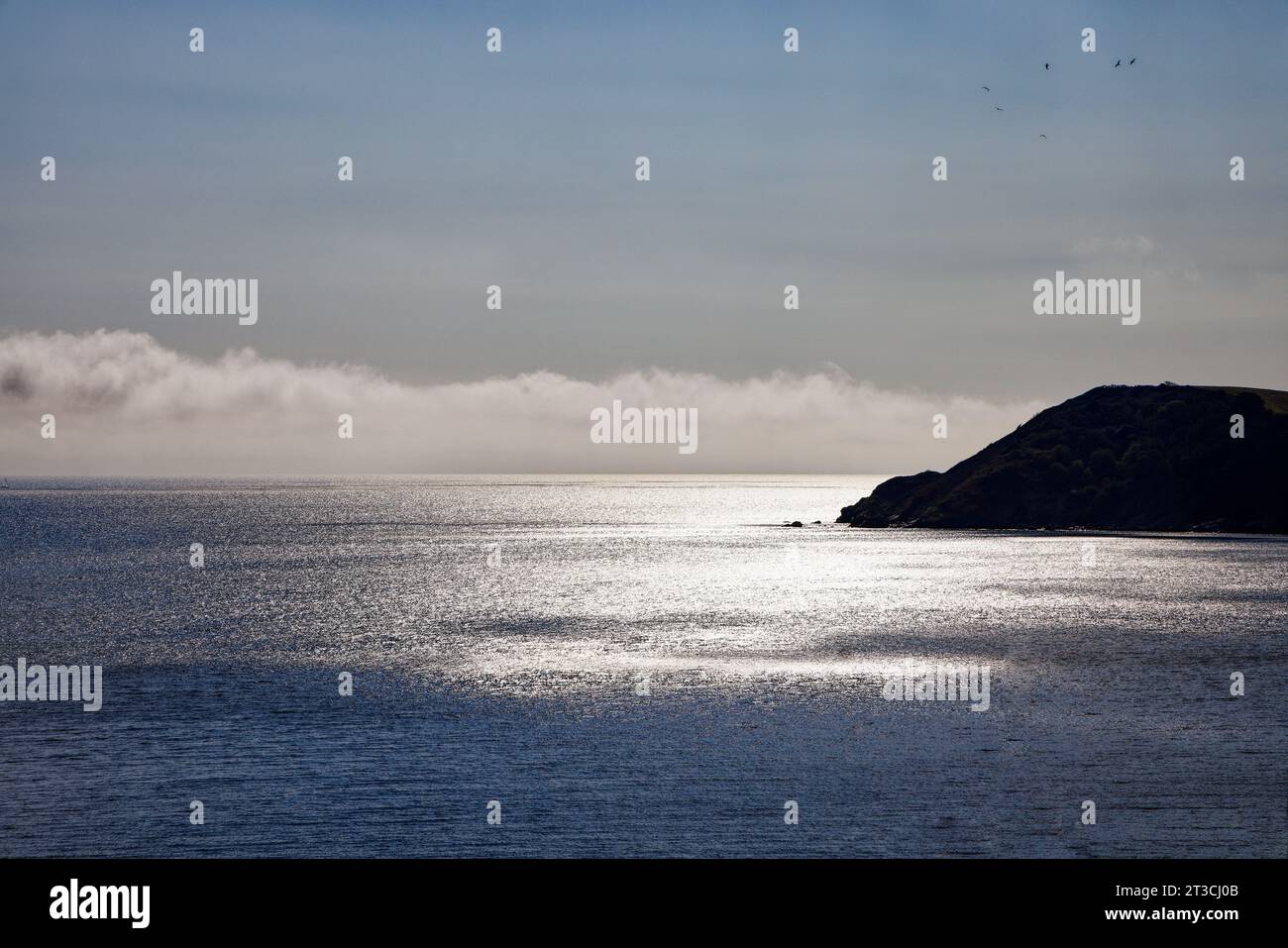 Il sole si riflette sulle calme acque di St Austell Bay, Cornovaglia. Foto Stock