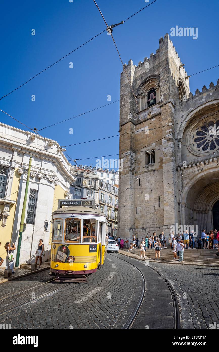 Tram giallo che passa di fronte alla cattedrale di Lisbona, Portogallo, il 12 ottobre 2023 Foto Stock