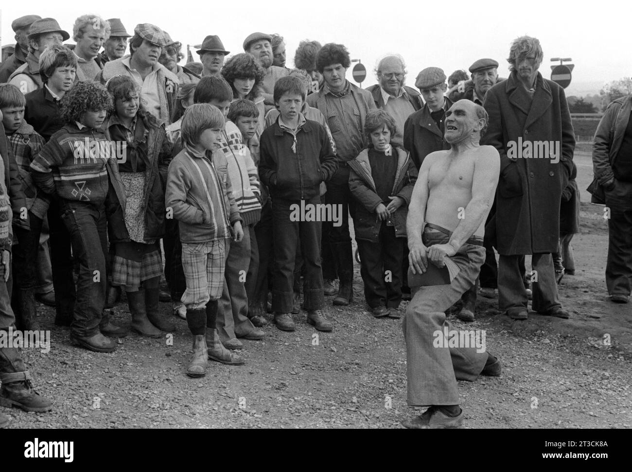 Johnny Eagle il famoso gitano Strongman, showman ed escapologo, visto da una folla di viaggiatori, strappa un libro a metà. Appleby a Westmorland fiera dei cavalli gitani Cumbria, Inghilterra giugno 1981 1980S Regno Unito HOMER SYKES. Foto Stock