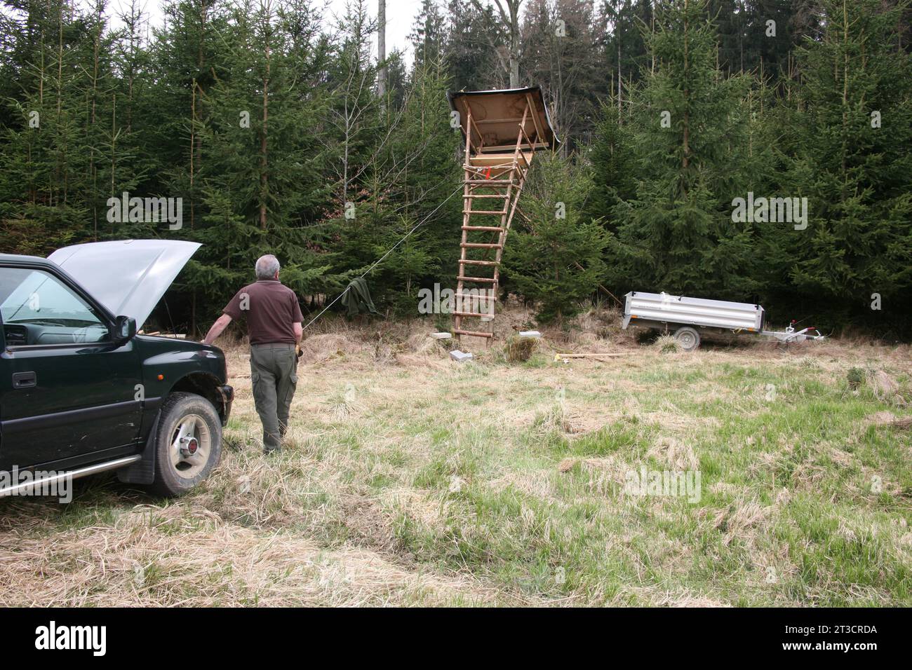 Allestire una tribuna di cacciatori ai margini della foresta con l'aiuto di un argano, Allgaeu, Baviera, Germania Foto Stock