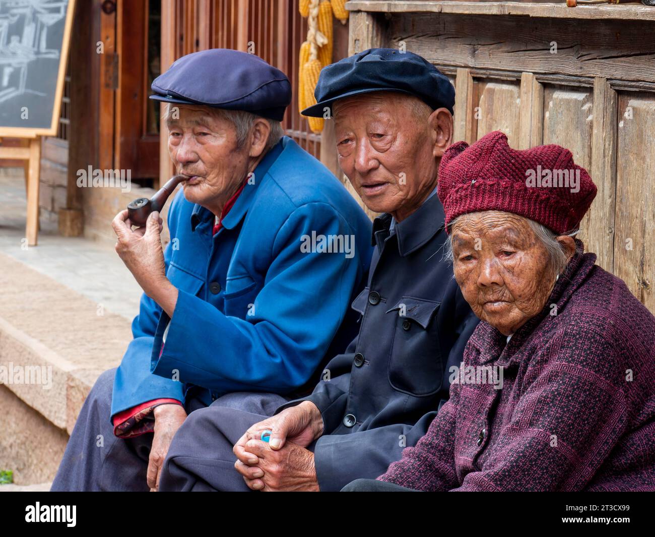 Anziani seduti davanti alla casa, pensionati cinesi, Shaxi, Yunnan, Cina Foto Stock