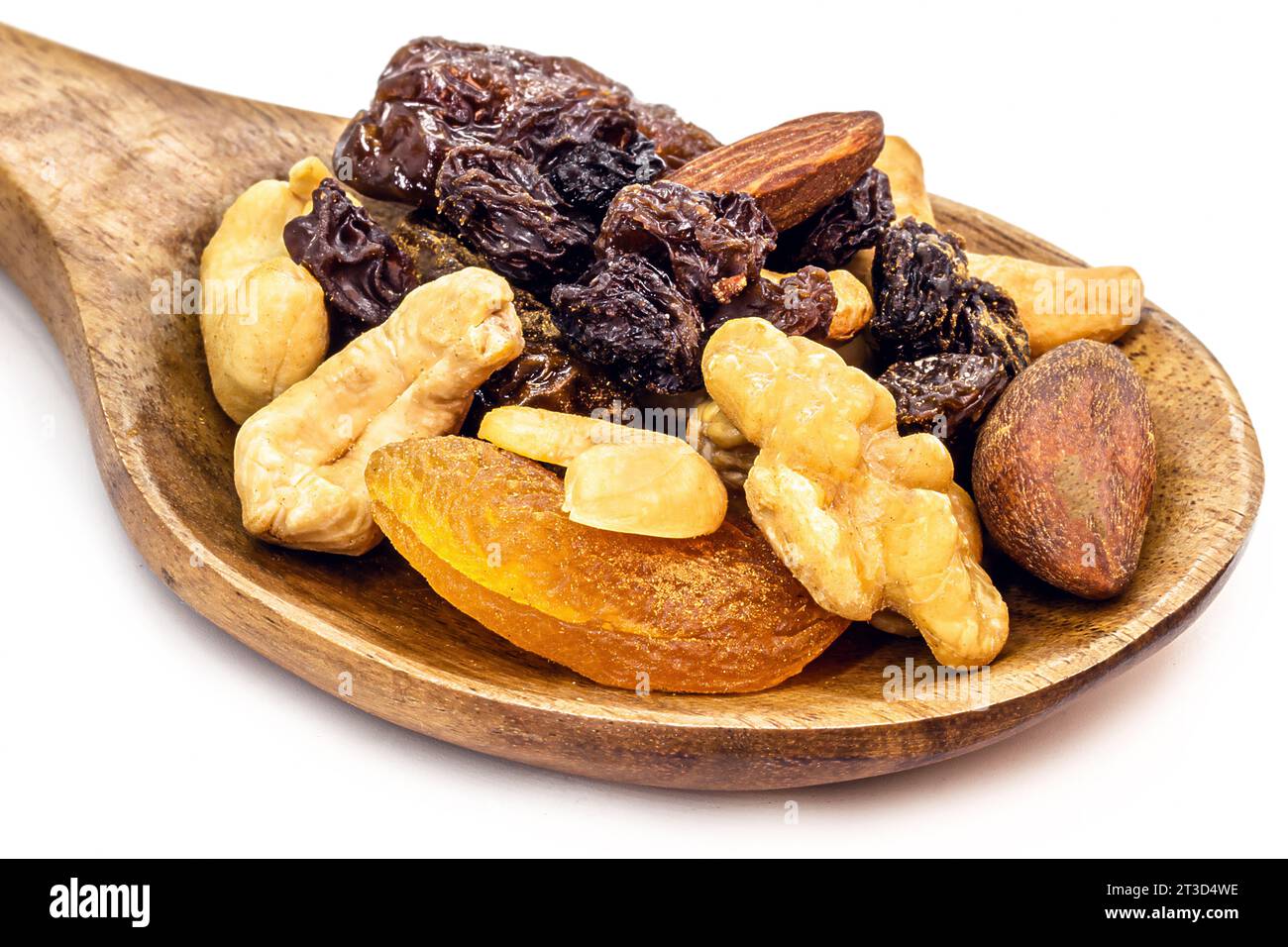 mescolare frutta secca e frutta disidratata in un cucchiaio di legno rustico. Noci del Brasile, albicocche, uva passa, prugne e noci Foto Stock