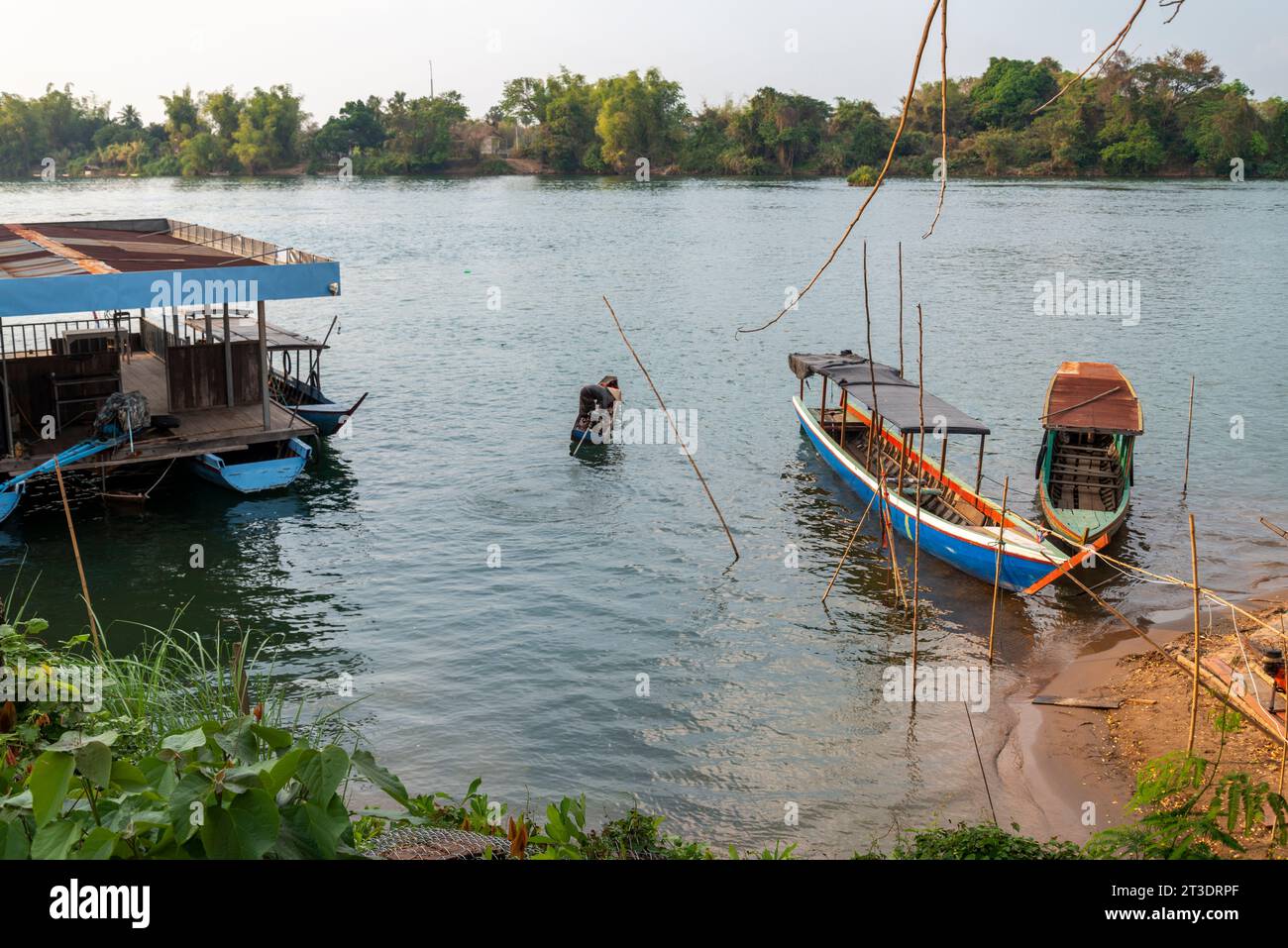 Piccola piattaforma galleggiante per traghetti, sul fiume Mekong, piccole barche in legno trasportano persone da e per le isole Nakasong e Don Som, presso il molo della spiaggia sabbiosa Foto Stock