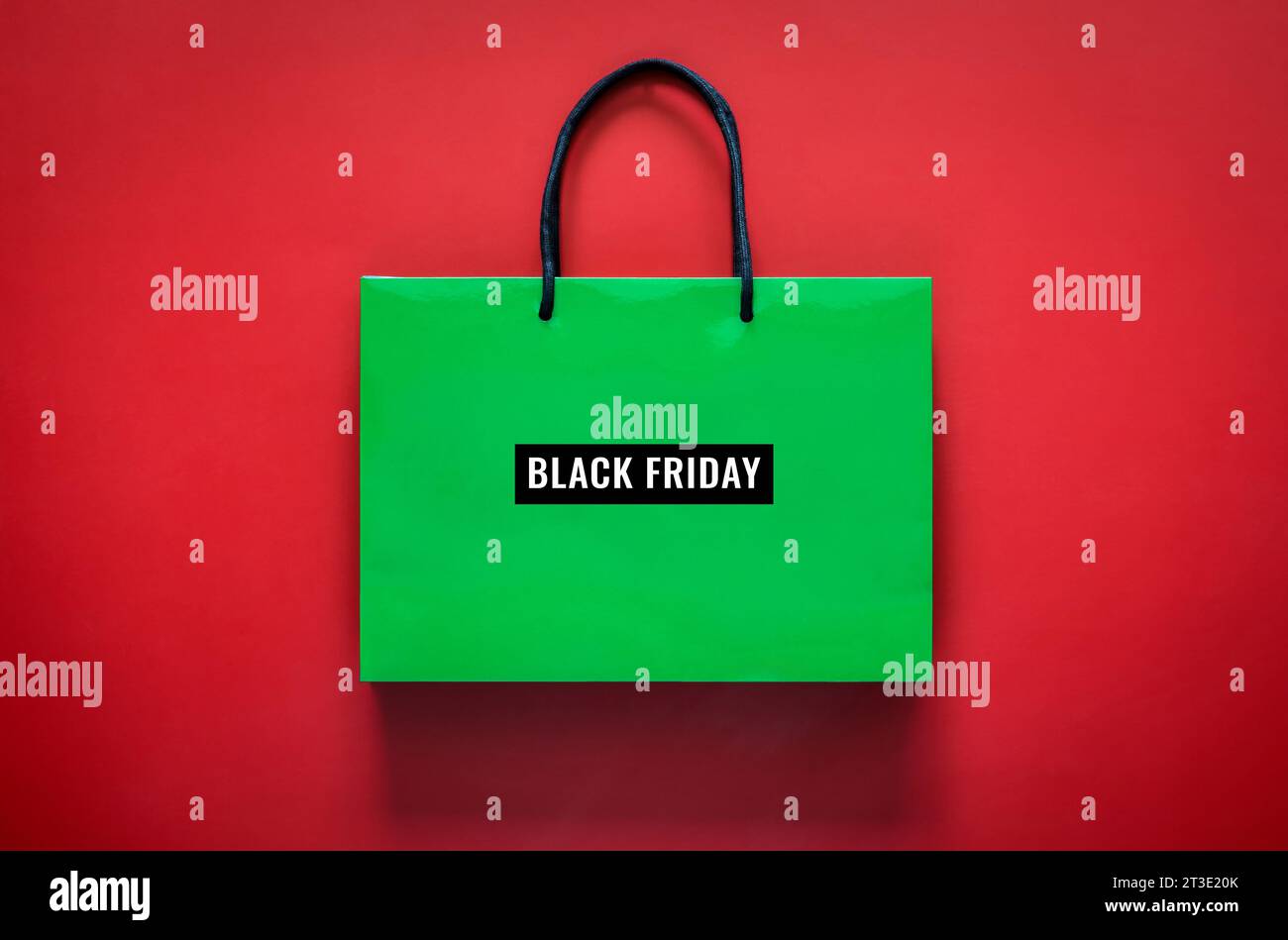 Shopping bag verde con scritta Black Friday su sfondo rosso per il concetto di shopping Black Friday. Foto Stock