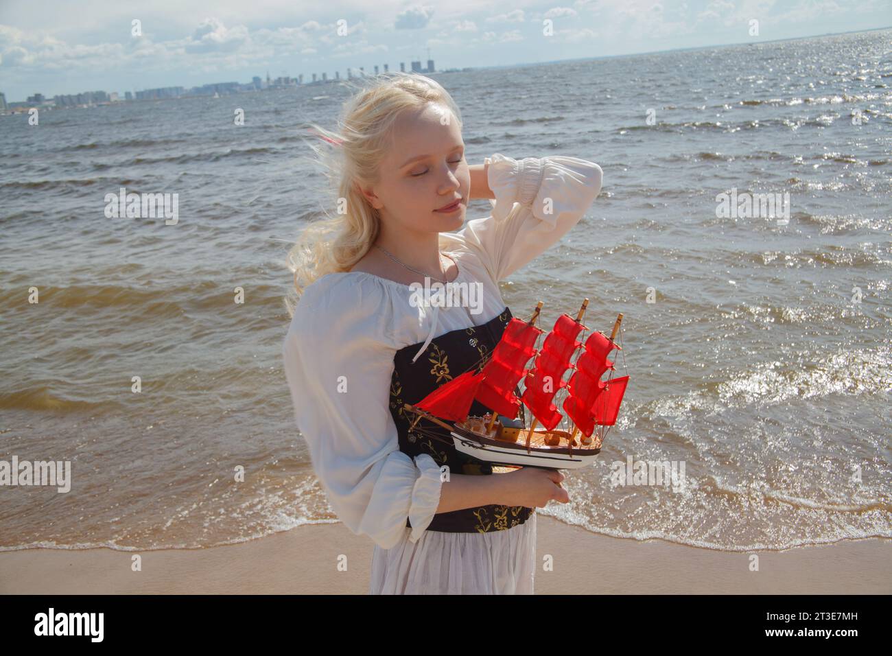 Romantica giovane donna che cammina all'aperto godendosi il mare Foto Stock