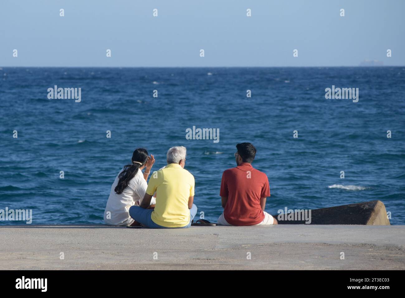 Persone sedute in riva al mare in un momento di relax Foto Stock