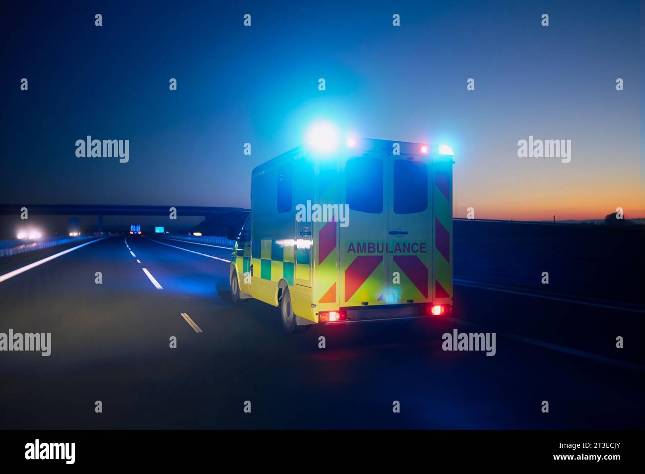 Auto ambulanza veloce di servizio medico di emergenza su autostrada di notte. Temi assistenza sanitaria, soccorso e urgenza. Foto Stock