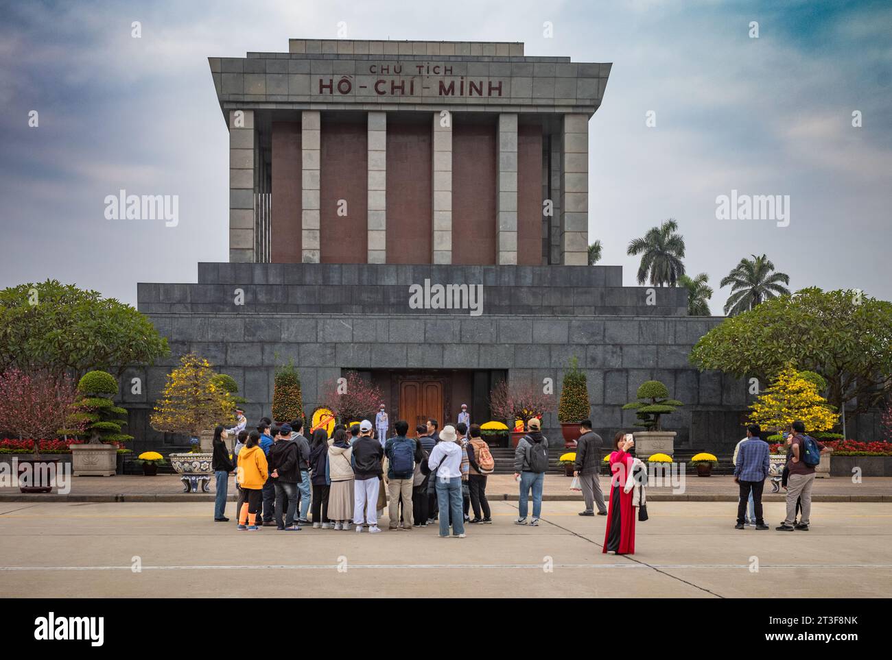 Un gruppo di turisti asiatici si trova fuori dal mausoleo di granito che ospita il corpo imbalsamato del venerato leader comunista vietnamita ho Chi Minh nel capi Foto Stock