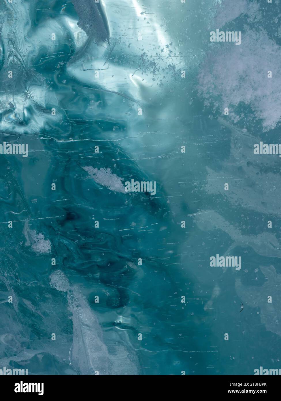 Consistenza di ghiaccio ghiacciato di un lago di montagna. Spessore del ghiaccio verde-blu attraverso il quale è visibile la luce Foto Stock
