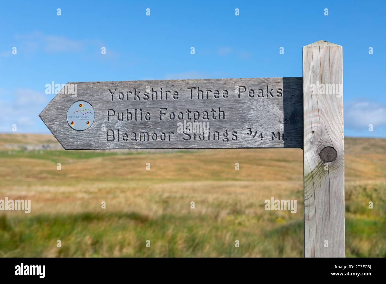Un cartello di legno per il sentiero pubblico Yorkshire Three Peaks che indica i binari di Bleamoor Foto Stock