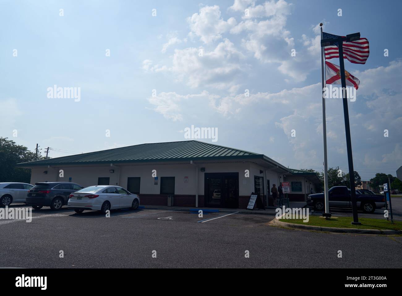 Esterno del centro servizi della contea di Escambia con bandiere americane e della Florida Foto Stock