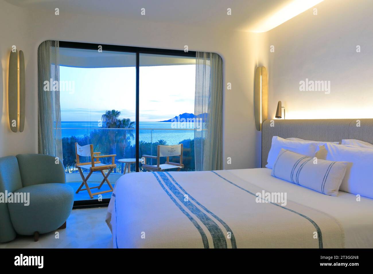Francia, Alpes Maritimes, Cannes, Hotel Belle Plage decorato dal designer d'interni Raphael Navot, camera con vista mare al calar della notte Foto Stock