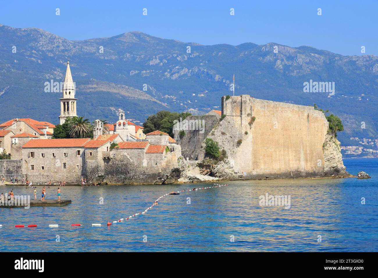 Montenegro, costa adriatica, Budva, città vecchia (Stari Grad) e St Chiesa di Giovanni (a sinistra) con la spiaggia in primo piano Foto Stock