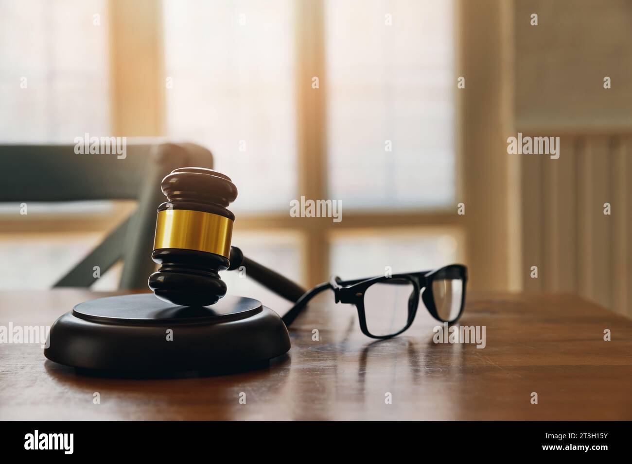 Gavel di legno e bicchieri a tavola in ufficio dell'avvocato. Foto Stock