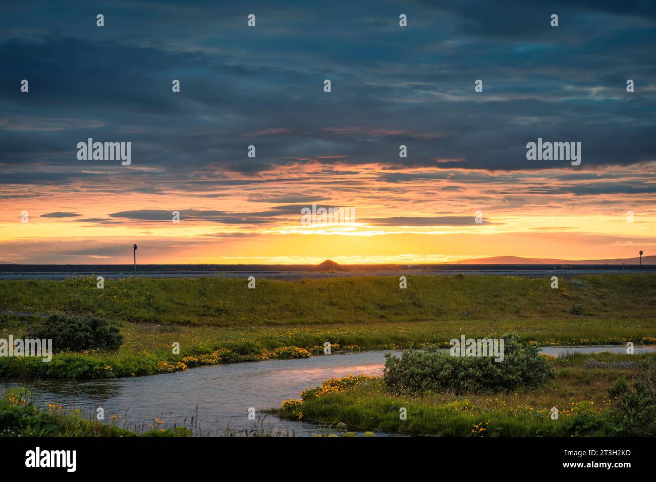 Splendida scena rurale di tramonto su prato con ruscello in estate Foto Stock