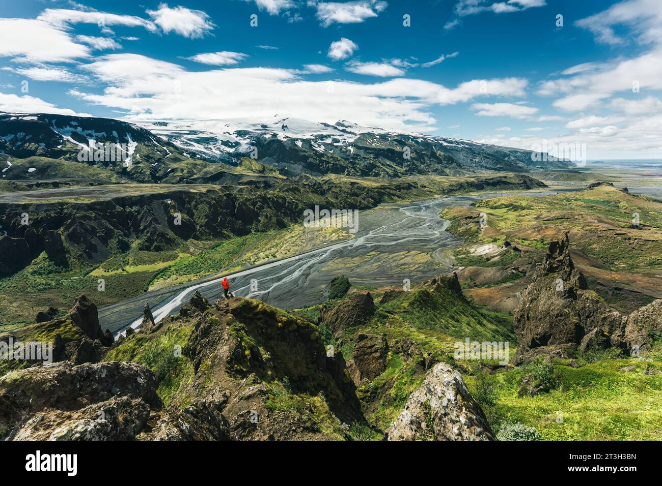 Suggestivo paesaggio vulcanico di sentiero valahnukur con un escursionista in piedi e il fiume Krossa a Thormork nelle Highlands dell'Islanda Foto Stock