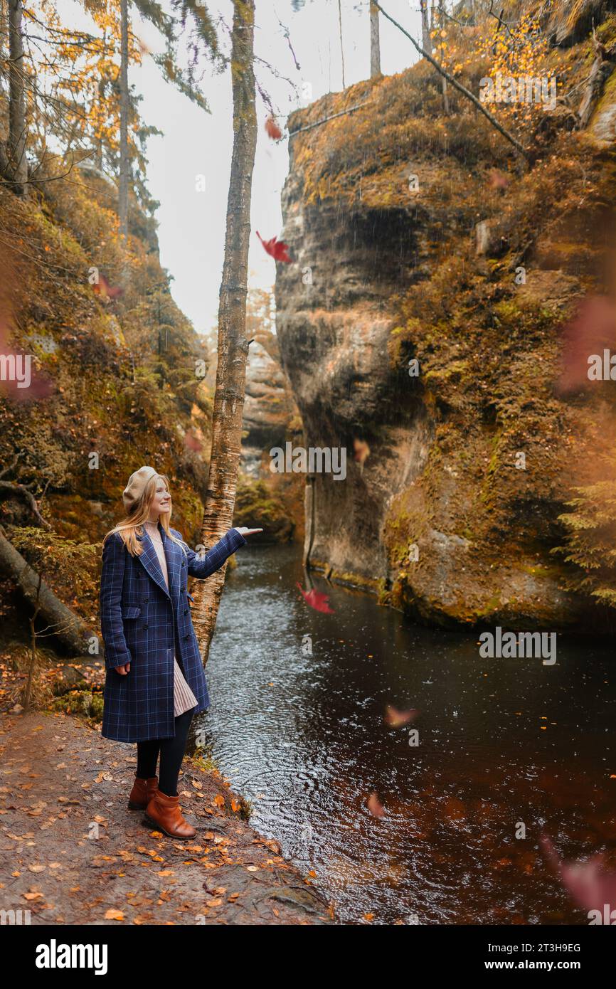 donna con berretto vicino al lago in autunno Foto Stock