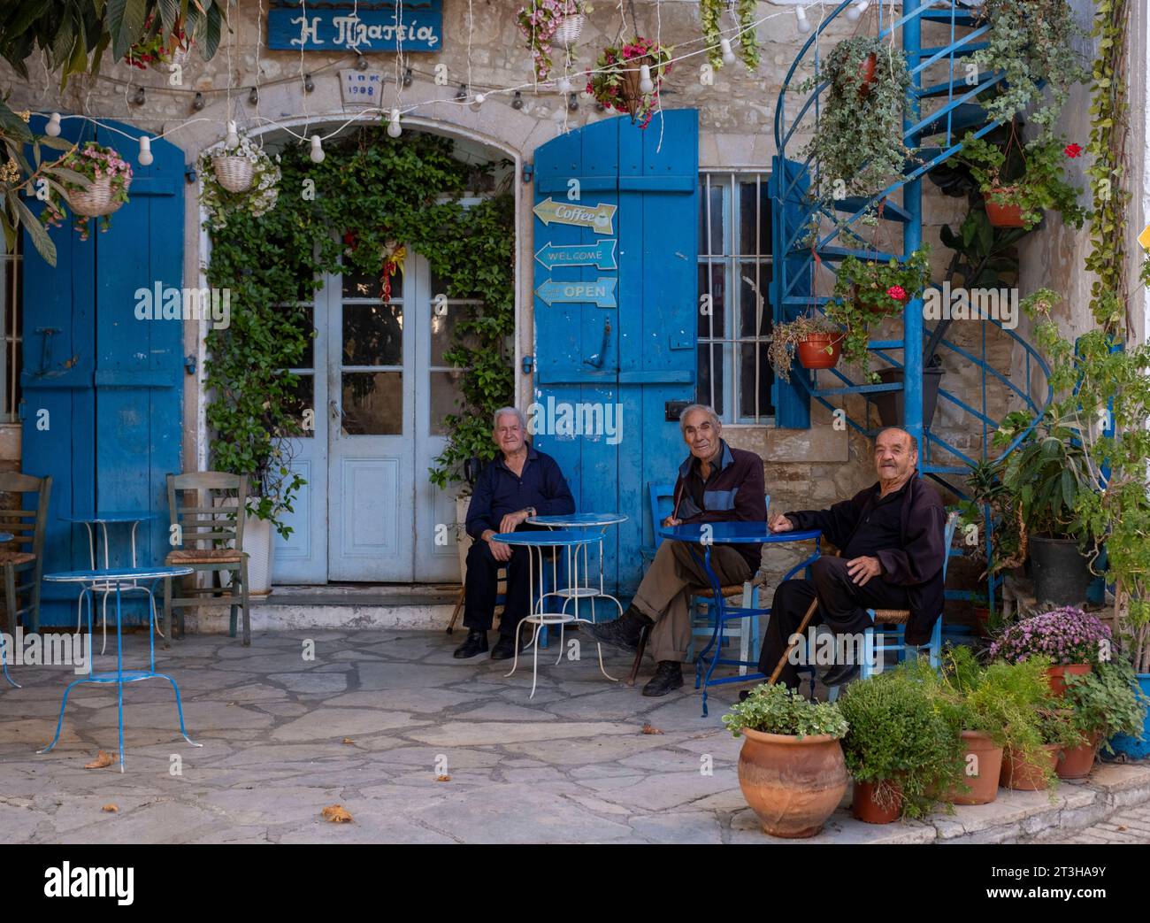 Uomini anziani siedono a chiacchierare fuori dalla storica caffetteria Plateia (The Square) nel villaggio di Vouni, distretto di Limassol, Cipro. Foto Stock