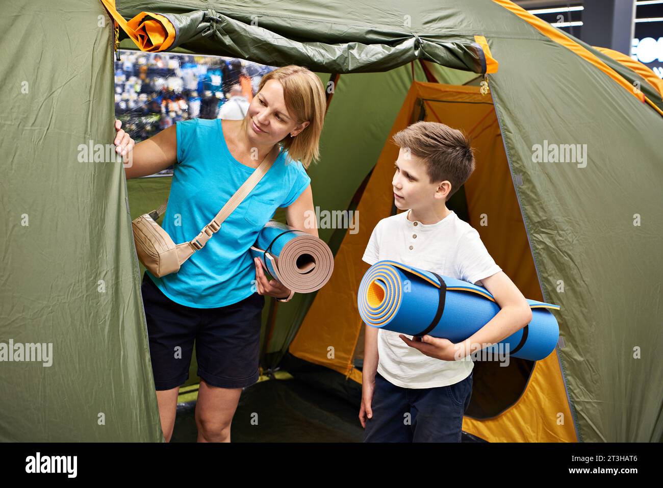 Mamma e figlio scelgono una tenda da campeggio in negozio Foto Stock