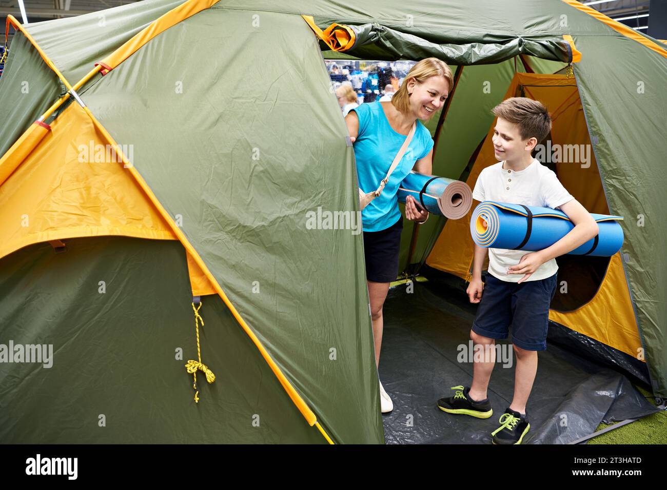 Donna e ragazzo scelgono una tenda da campeggio nel negozio Foto Stock