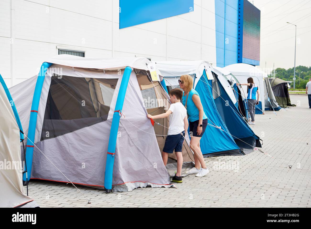 Donna e ragazzo scelgono una tenda da campeggio nel negozio Foto Stock
