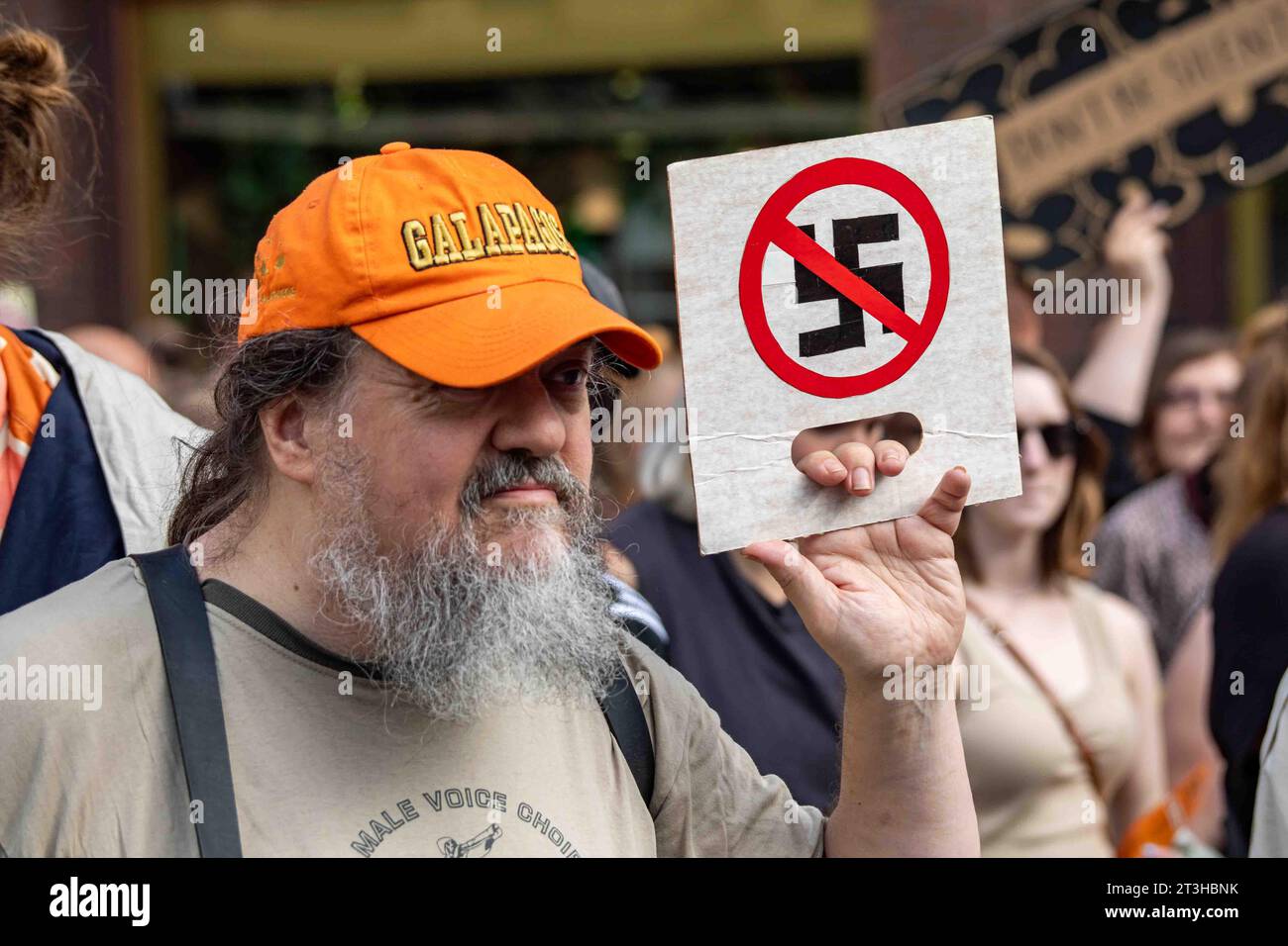 Uomo barbato grigio con un piccolo cartello di cartone con una svastica barrata su di me emme vaikene! Manifestazione anti-rasicm a Helsinki, Finlandia Foto Stock
