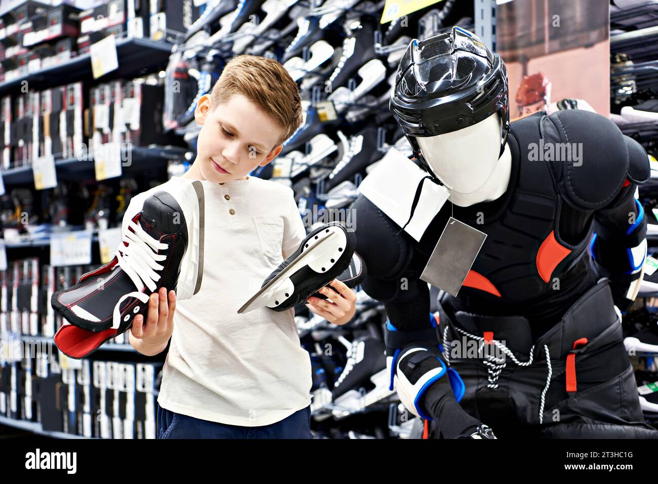 Ragazzo con pattini in un negozio di attrezzature da hockey Foto Stock